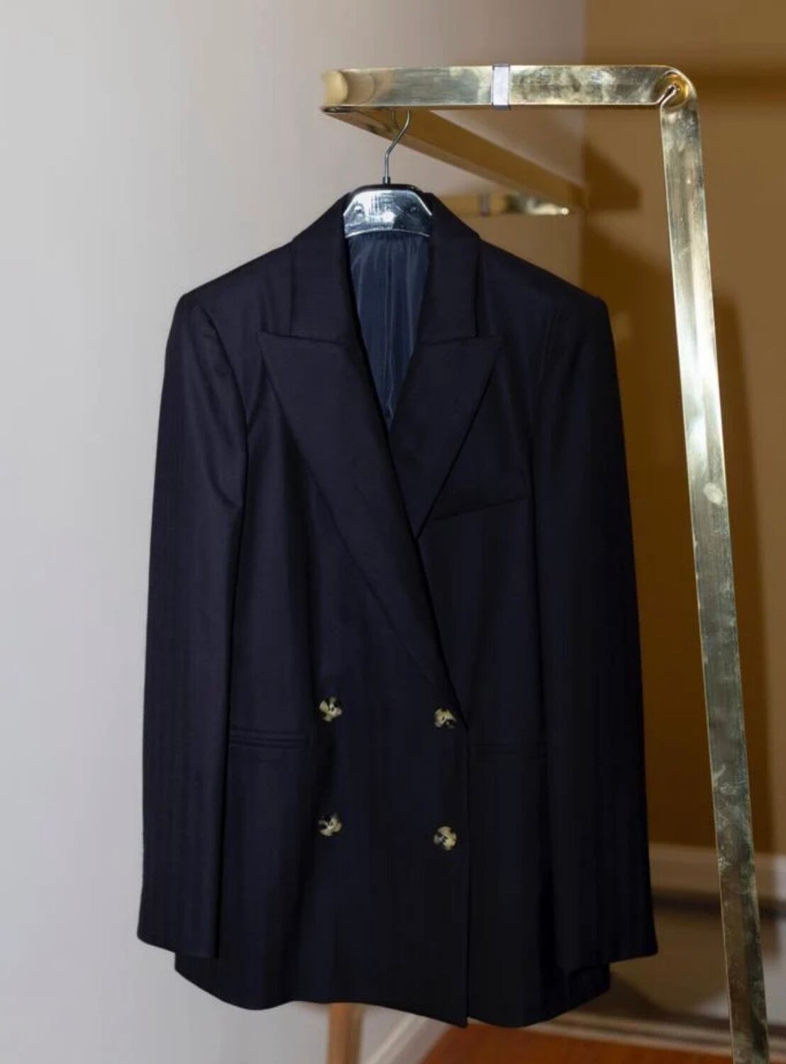 Un blazer blu su una gruccia dalla spalla larga